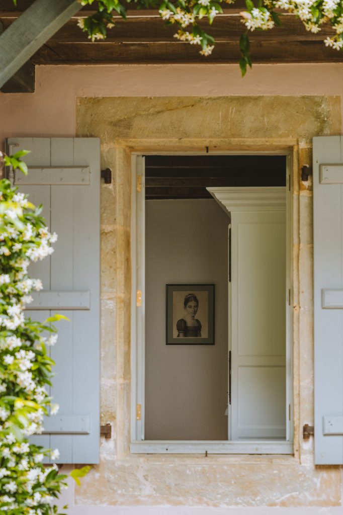 Fenêtre ouverte du Couvent avec volets bleus et portrait ancien à l’intérieur.