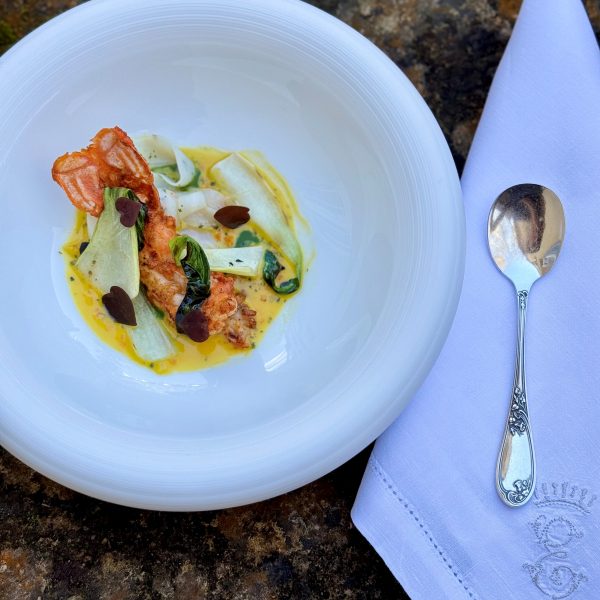 Plat gastronomique du restaurant 3 étoiles Michelin Michel Guérard : langoustine dorée au beurre d’épices, accompagnée de rubans de seiche et d’une sauce onctueuse à base de nage de homard et beurre de mer.